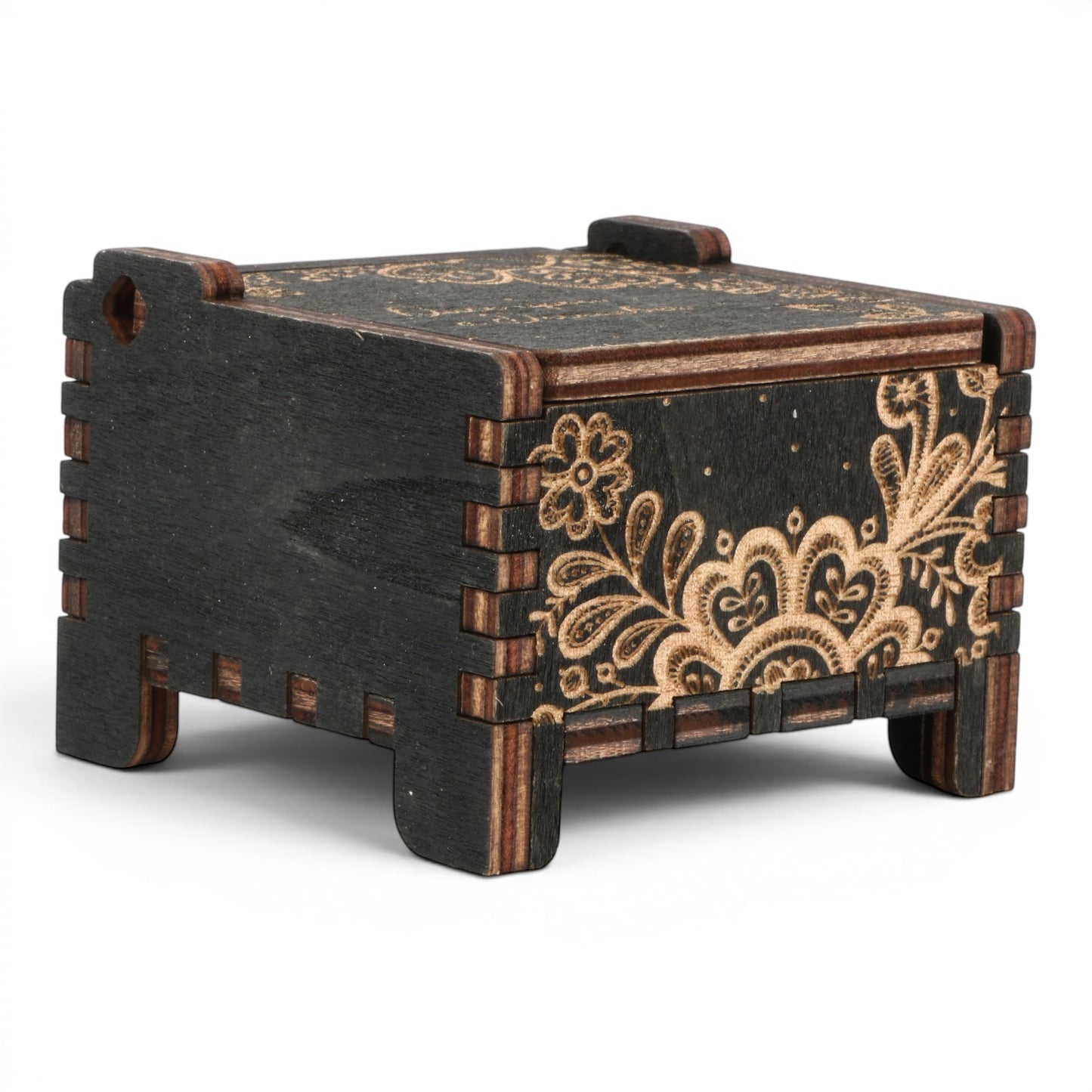 Side view Enchanted Music Boxes wind-up music box in black plywood with intricate laser-engraved floral folk art patterns.