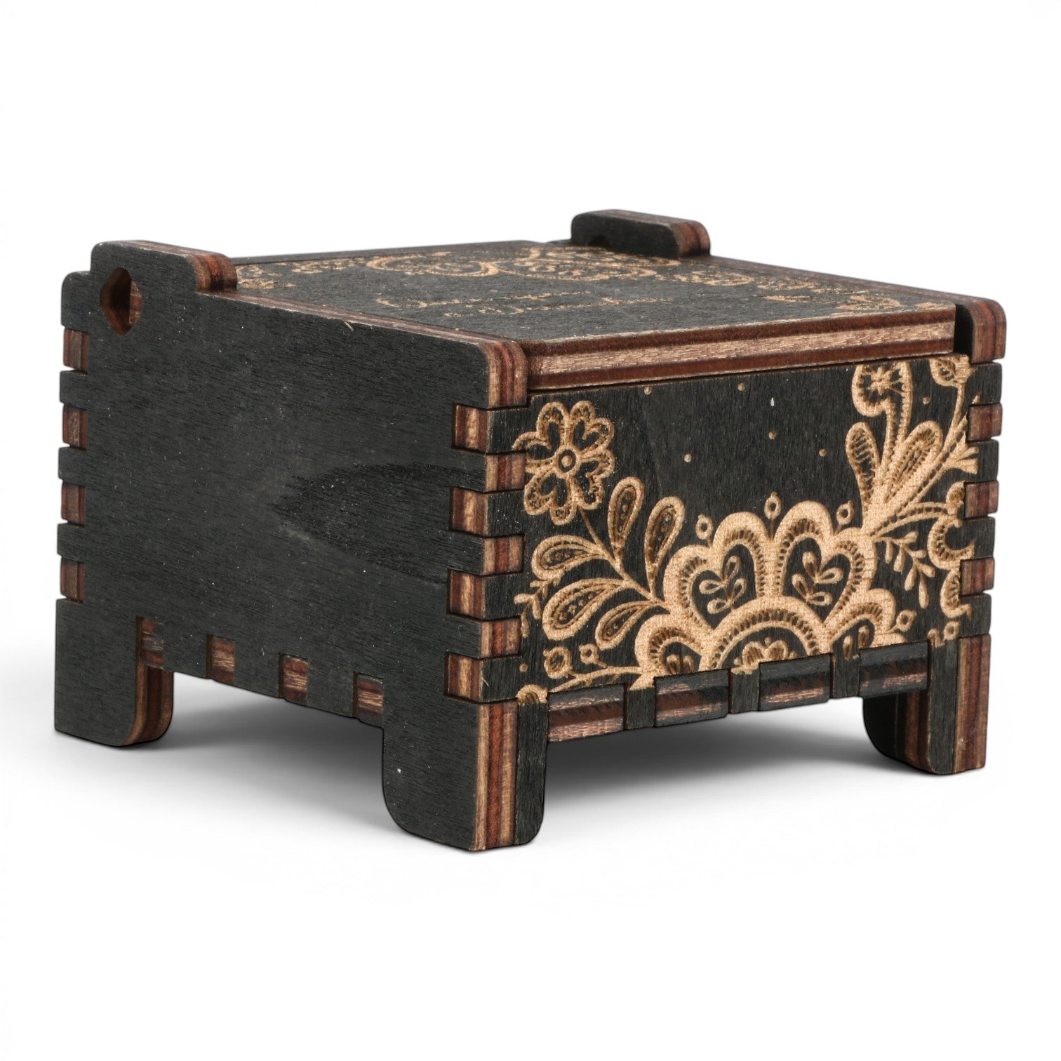 Side view Enchanted Music Boxes wind-up music box in black plywood with intricate laser-engraved floral folk art patterns.