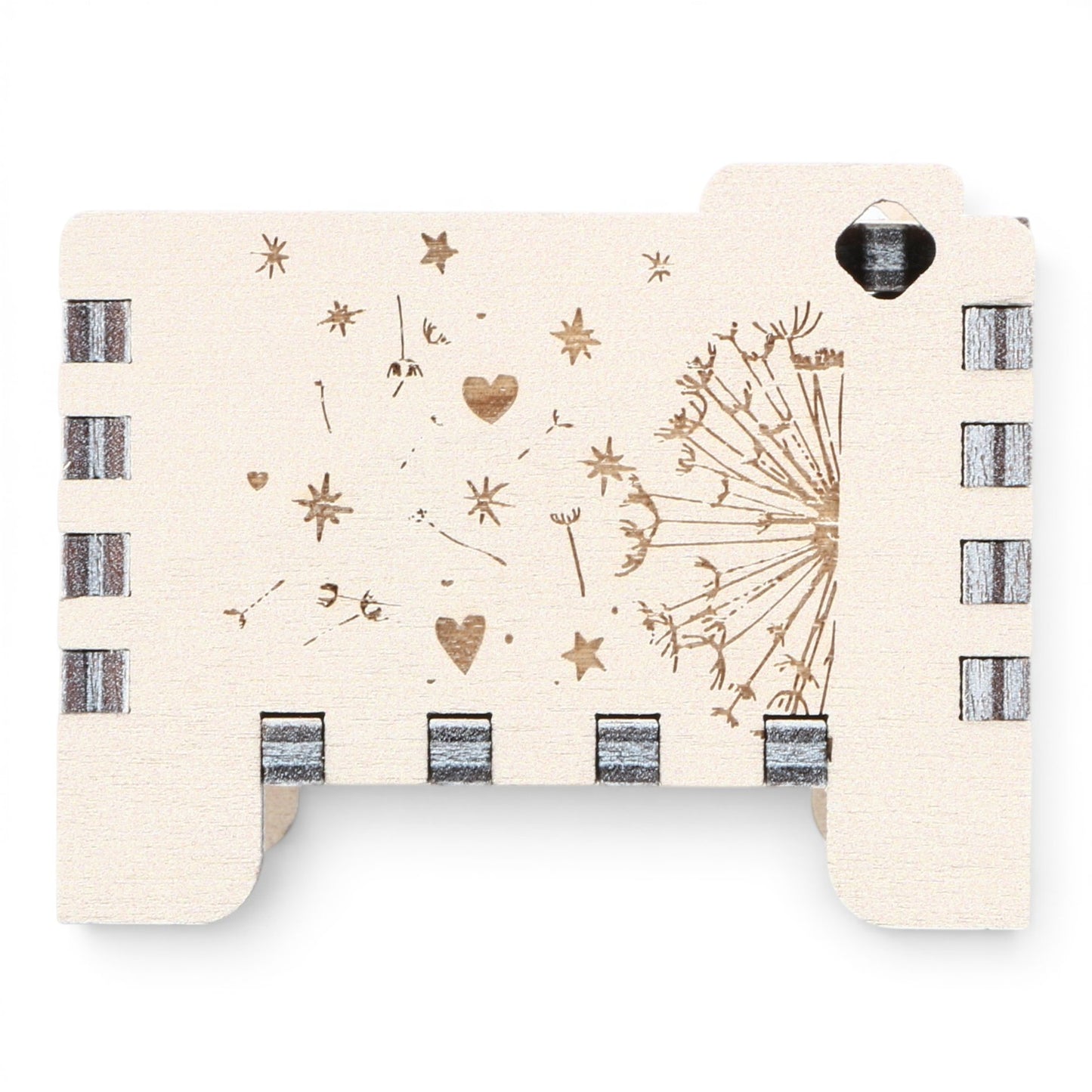 Side view of Enchanted Music Boxes plywood wind-up music box featuring laser-engraved dandelion seeds, hearts, and stars.