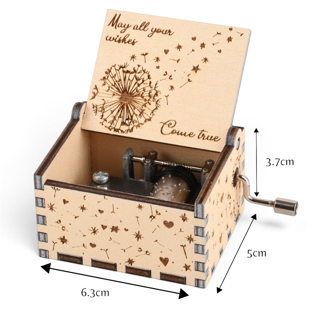 Enchanted Music Boxes hand-crank plywood music box featuring laser-engraved dandelion seeds, hearts, and stars.
