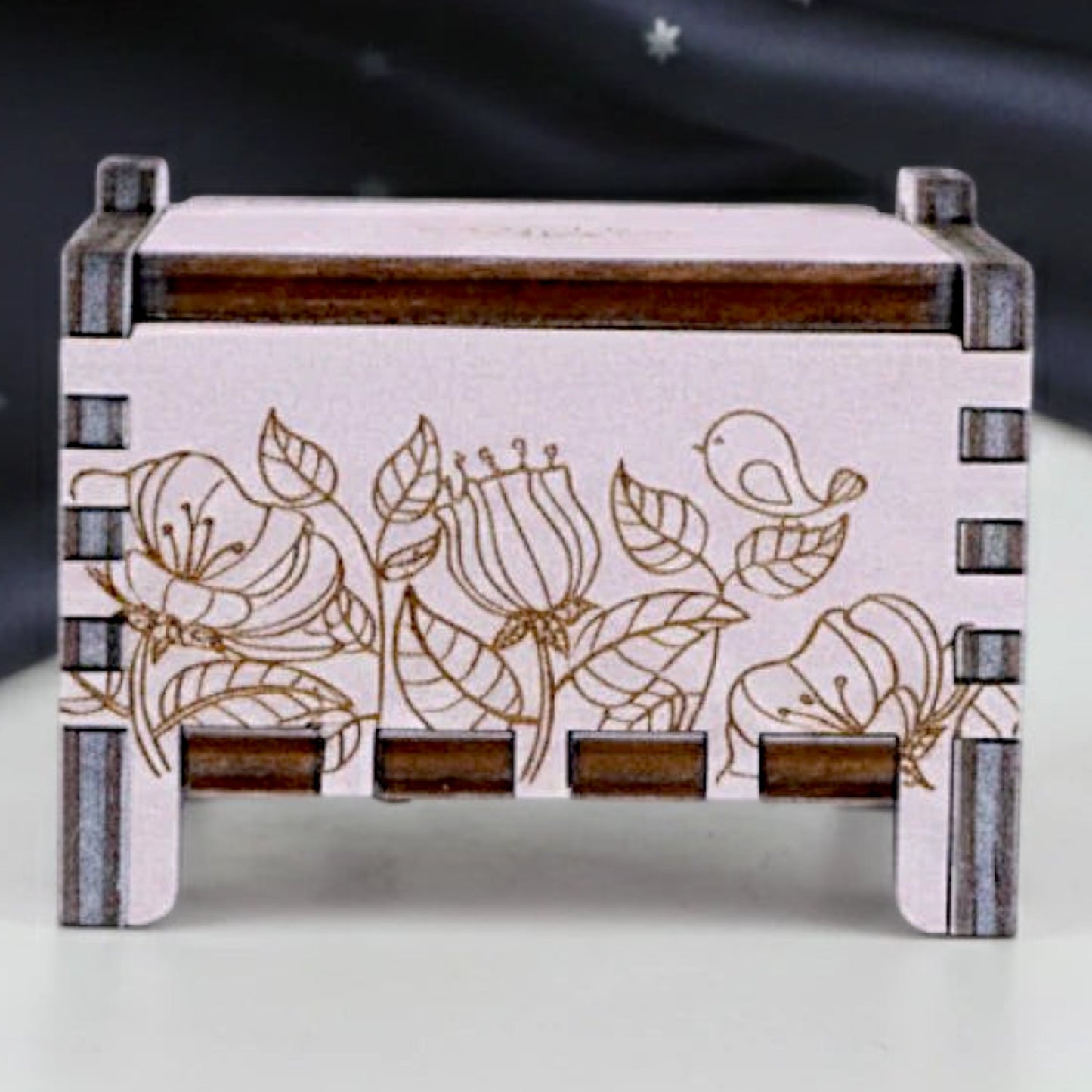 Front view of Enchanted Music Boxes wind-up plywood music box featuring intricate laser-engraved floral and bird designs.