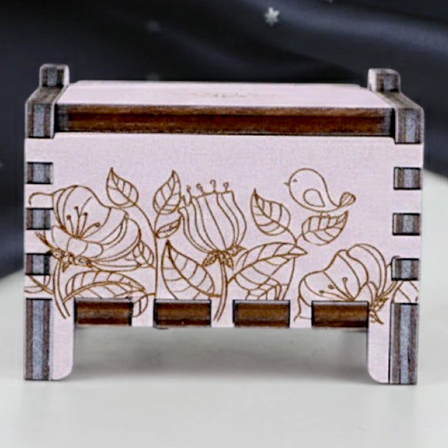 Front view of Enchanted Music Boxes wind-up plywood music box featuring intricate laser-engraved floral and bird designs.