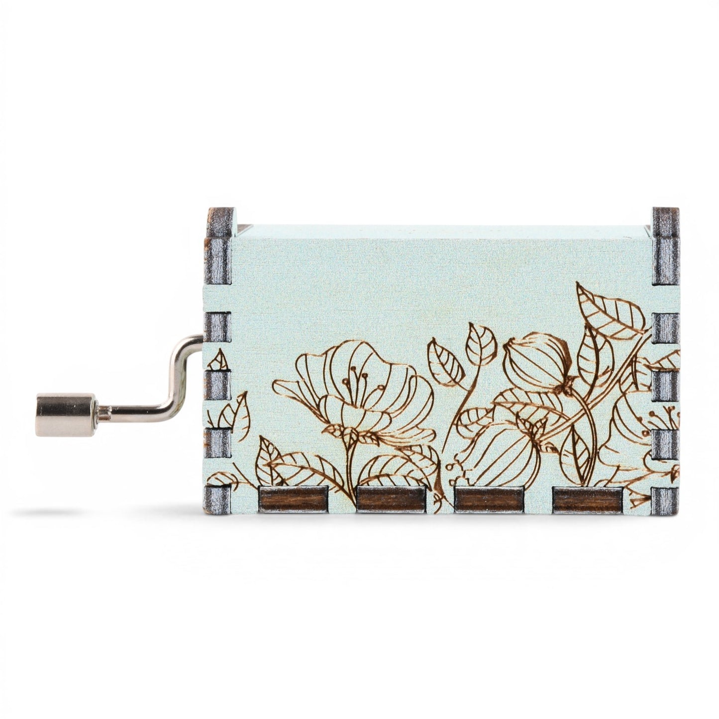 Enchanted Music Boxes hand-crank music box in light blue plywood with a laser-engraved floral design and metal crank.