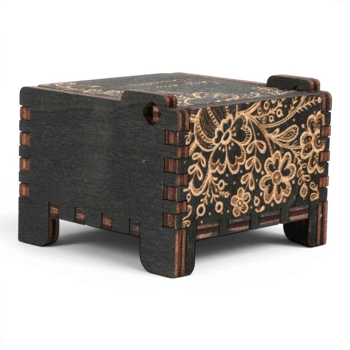 Side view of Enchanted Music Boxes wind-up music box in black plywood with intricate laser-engraved floral folk art patterns.
