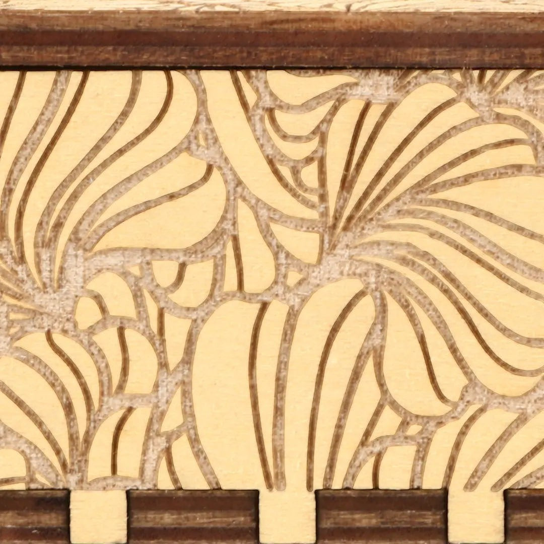 Close-up of Enchanted Music Boxes nature-inspired plywood music box featuring intricate laser-engraved flower petals.