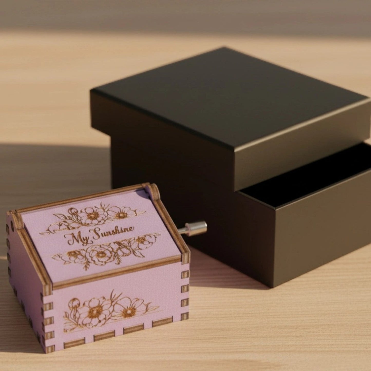 Enchanted Music Boxes lavender plywood music box with floral engravings and My Sunshine text next to a black gift box.