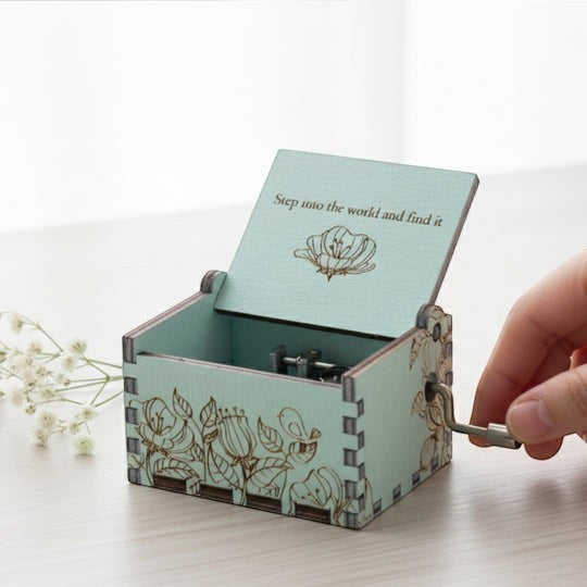 Enchanted Music Boxes hand-crank music box in mint green plywood with floral engravings and custom lid inscription.