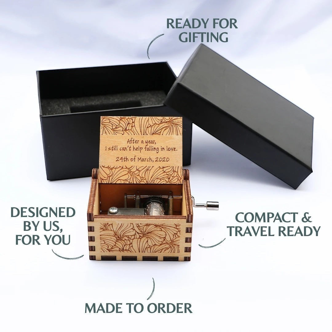 Enchanted Music Boxes nature-inspired plywood music box with custom laser-engraved lid message in a black gift box.