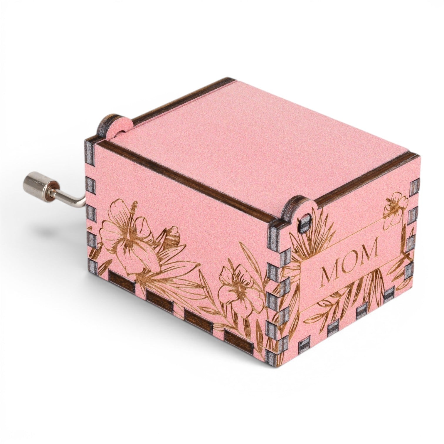 Enchanted Music Boxes pink plywood hand-crank music box with laser-engraved hibiscus flowers and MOM text on the side.