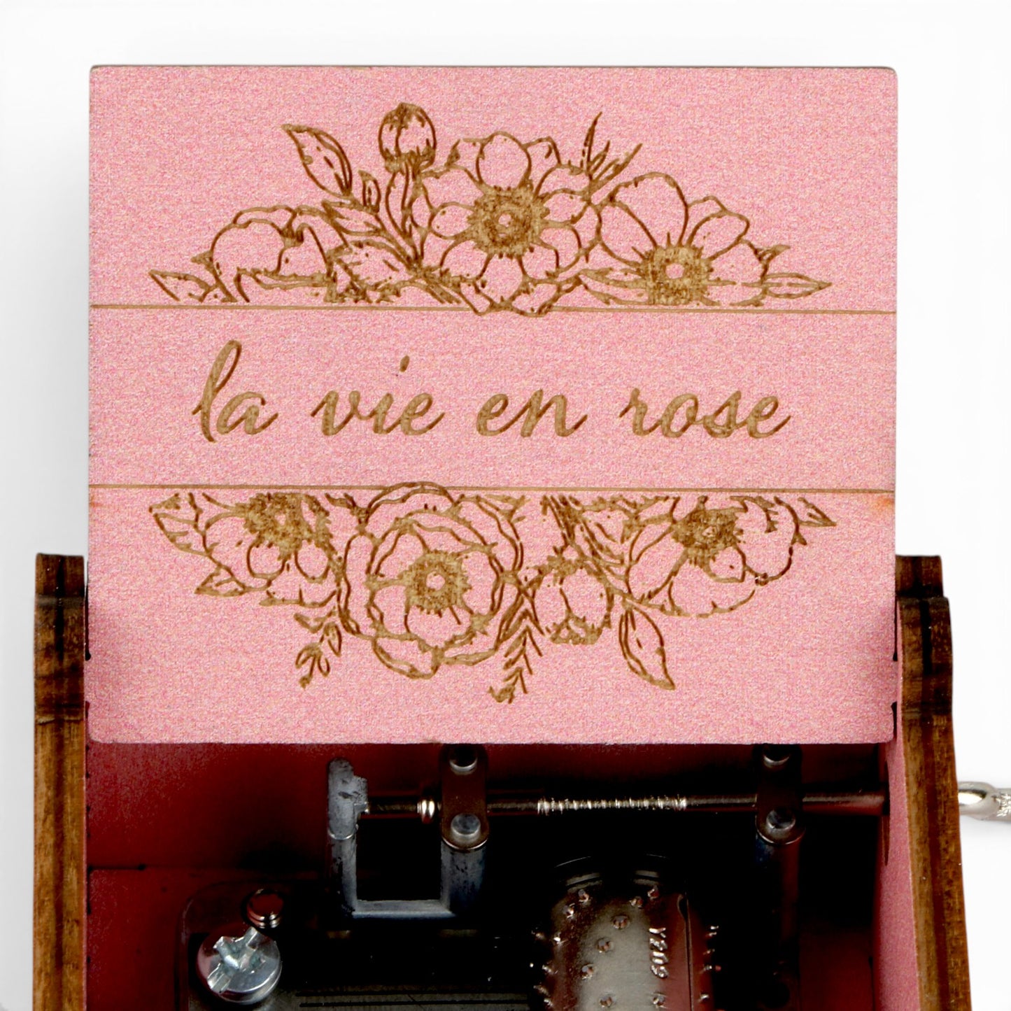 Enchanted Music Boxes pink plywood music box with floral engravings and the text la vie en rose on the open lid