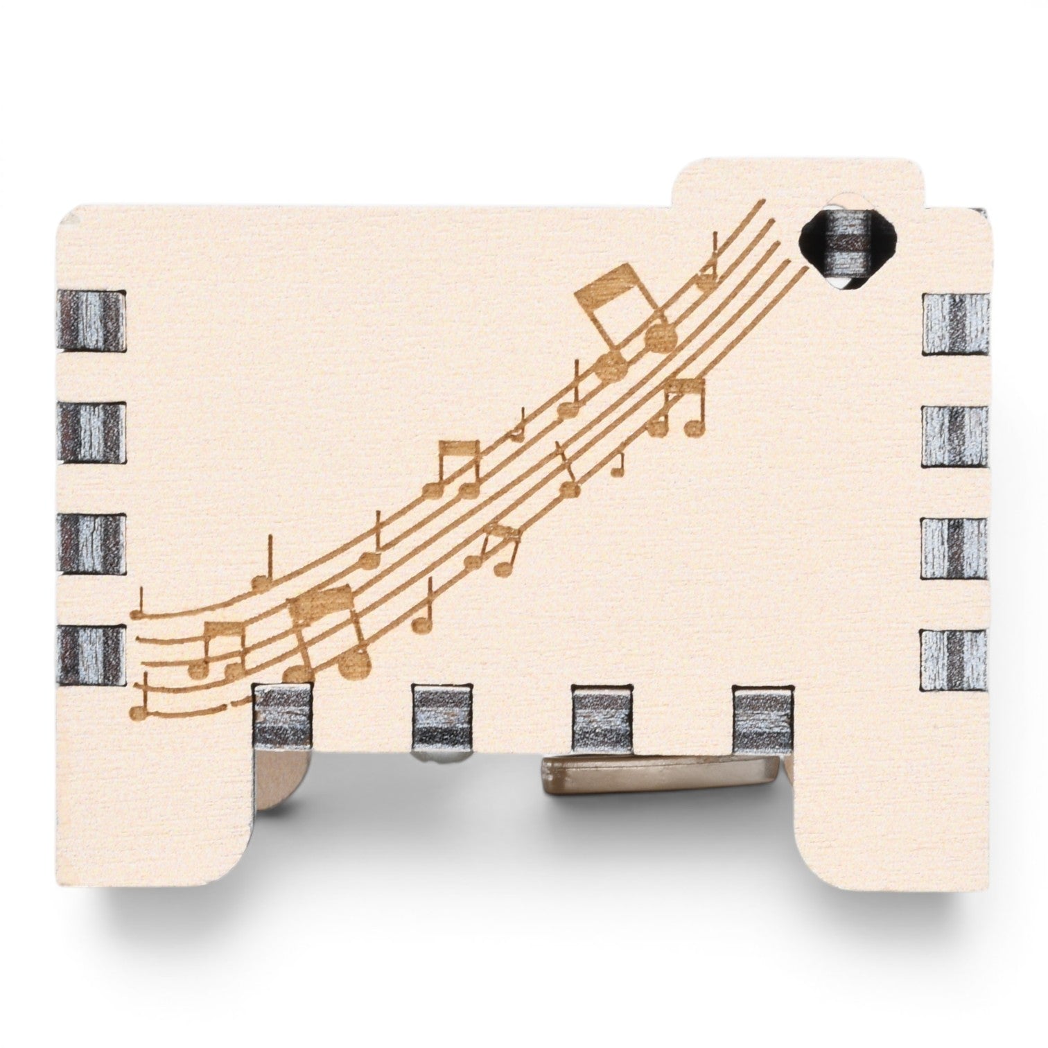 Enchanted Music Boxes plywood wind-up music box featuring engraved musical staves and notes on a light wood surface.
