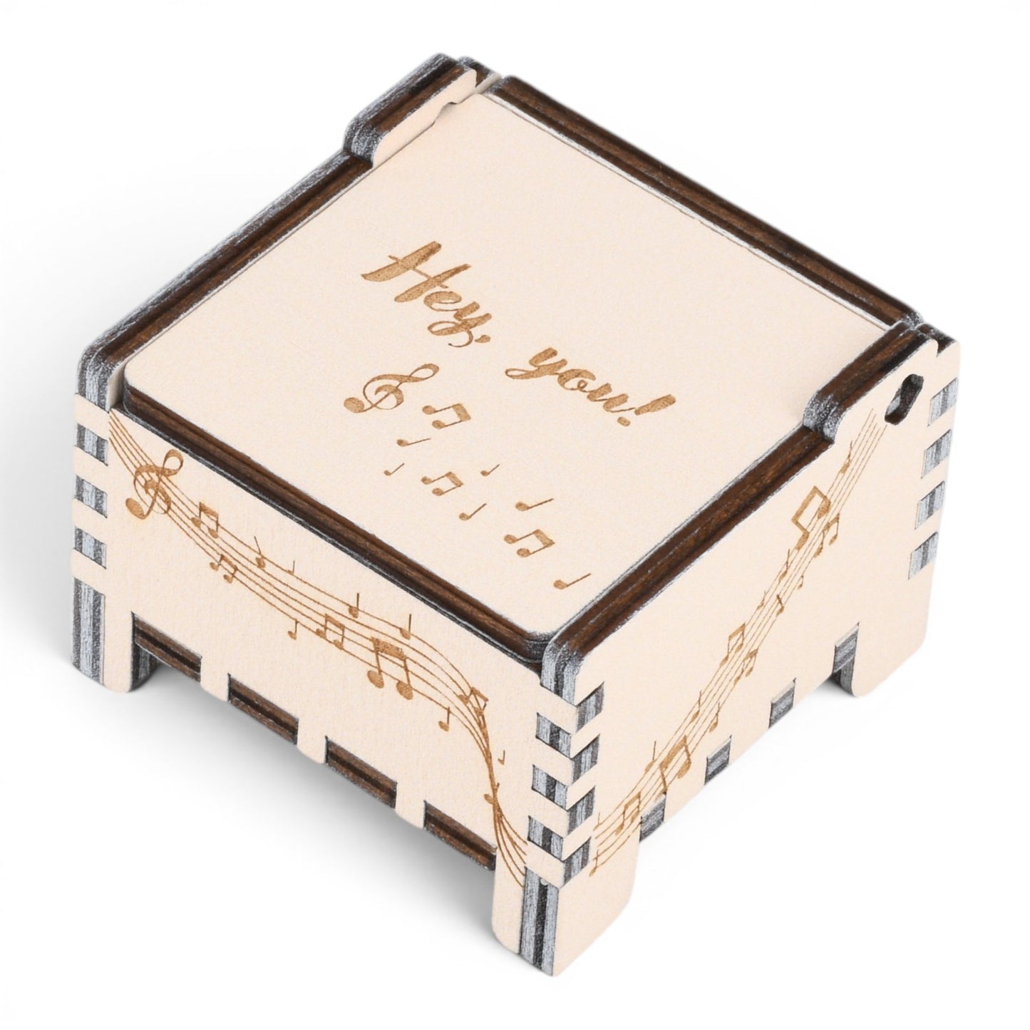 Enchanted Music Boxes plywood wind-up music box featuring engraved musical notes and cursive text on a light wood lid.