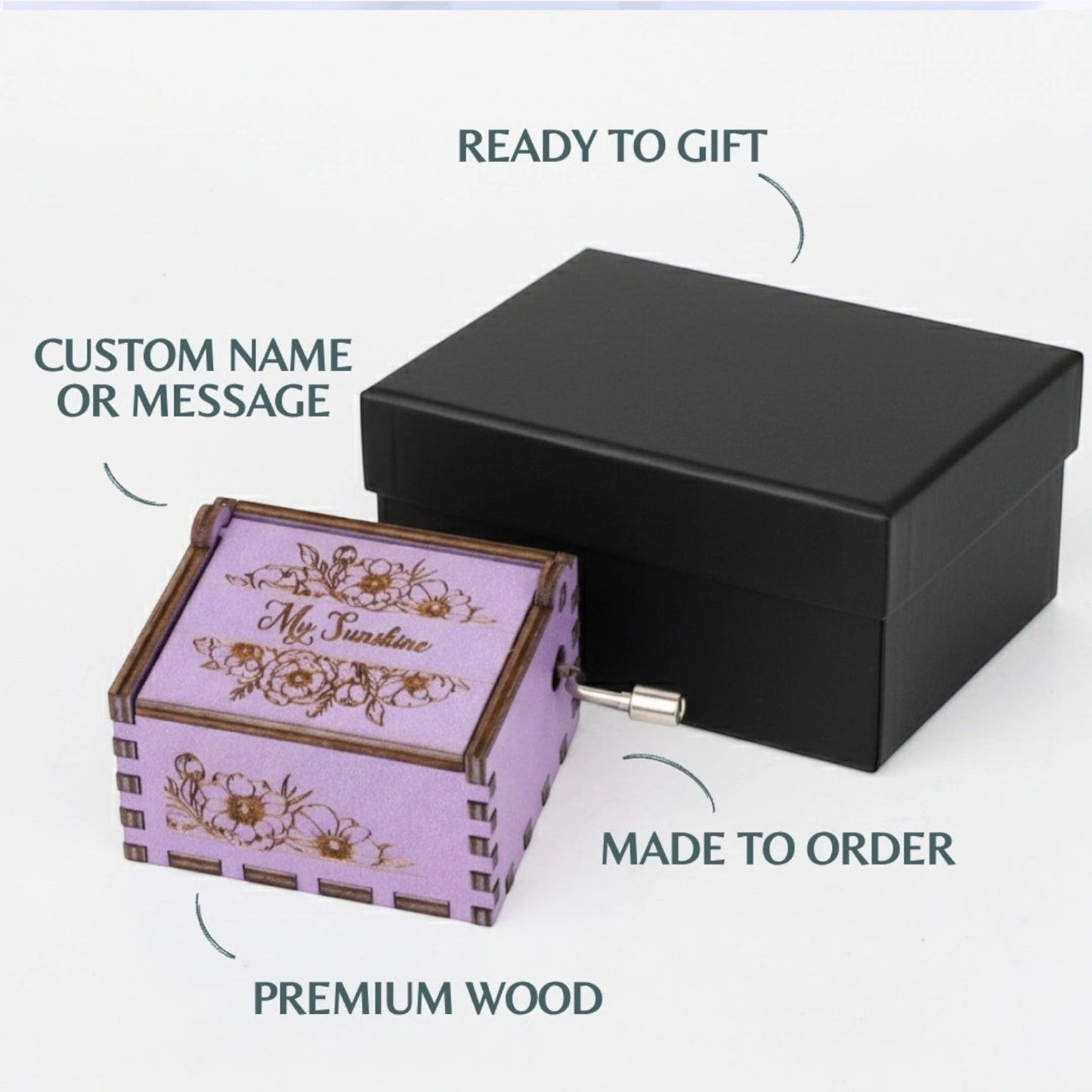 Enchanted Music Boxes purple wooden hand-crank music box with floral engravings and custom text in a black gift box.