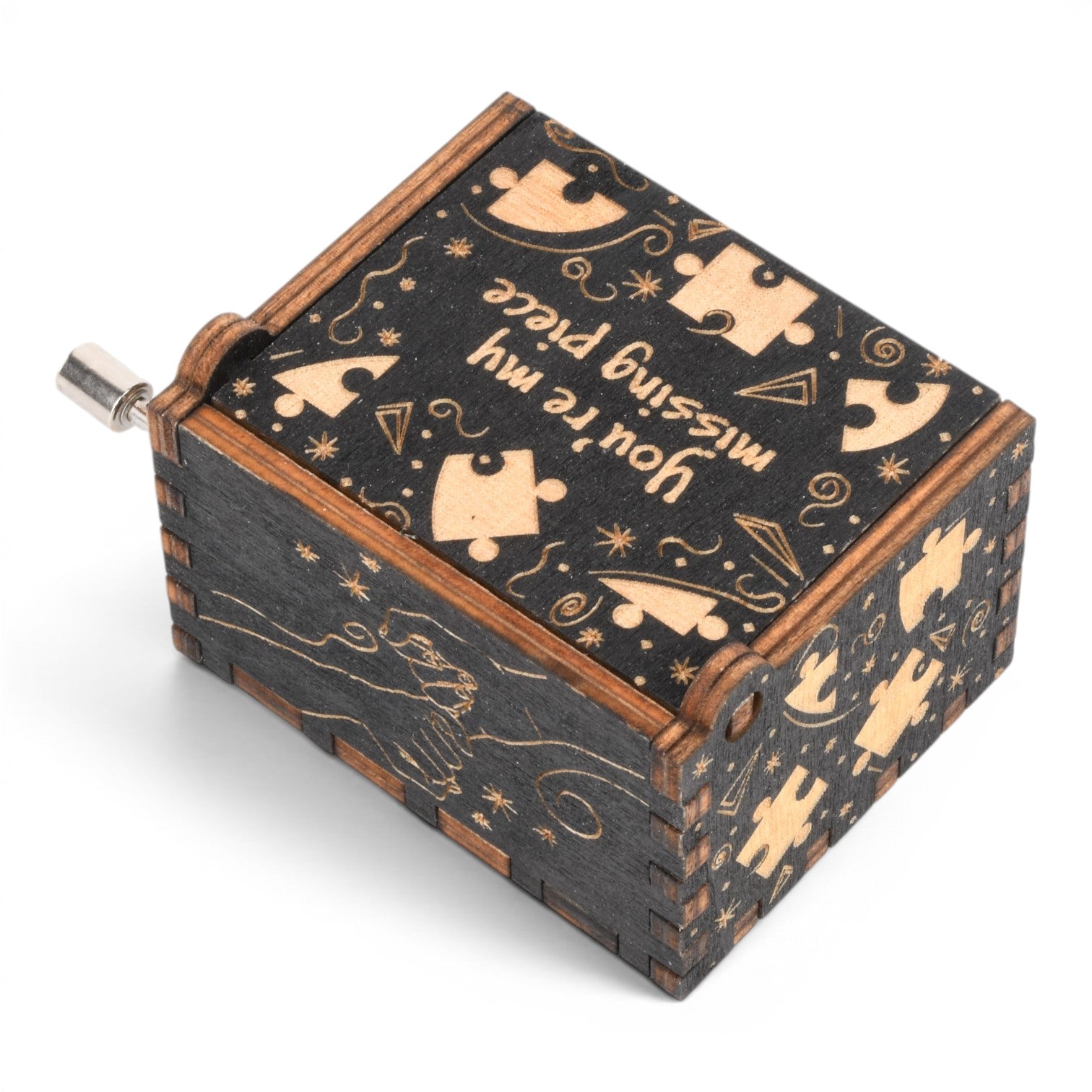 Enchanted Music Boxes plywood hand-crank music box with black finish, puzzle piece engravings, and heart-shaped hands.