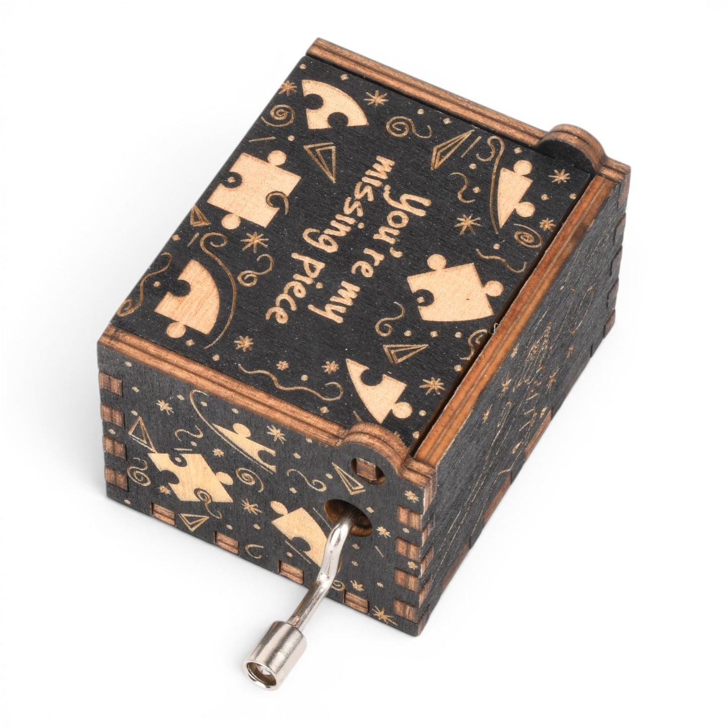 Enchanted Music Boxes plywood hand-crank music box with black finish, puzzle piece engravings, and romantic text.