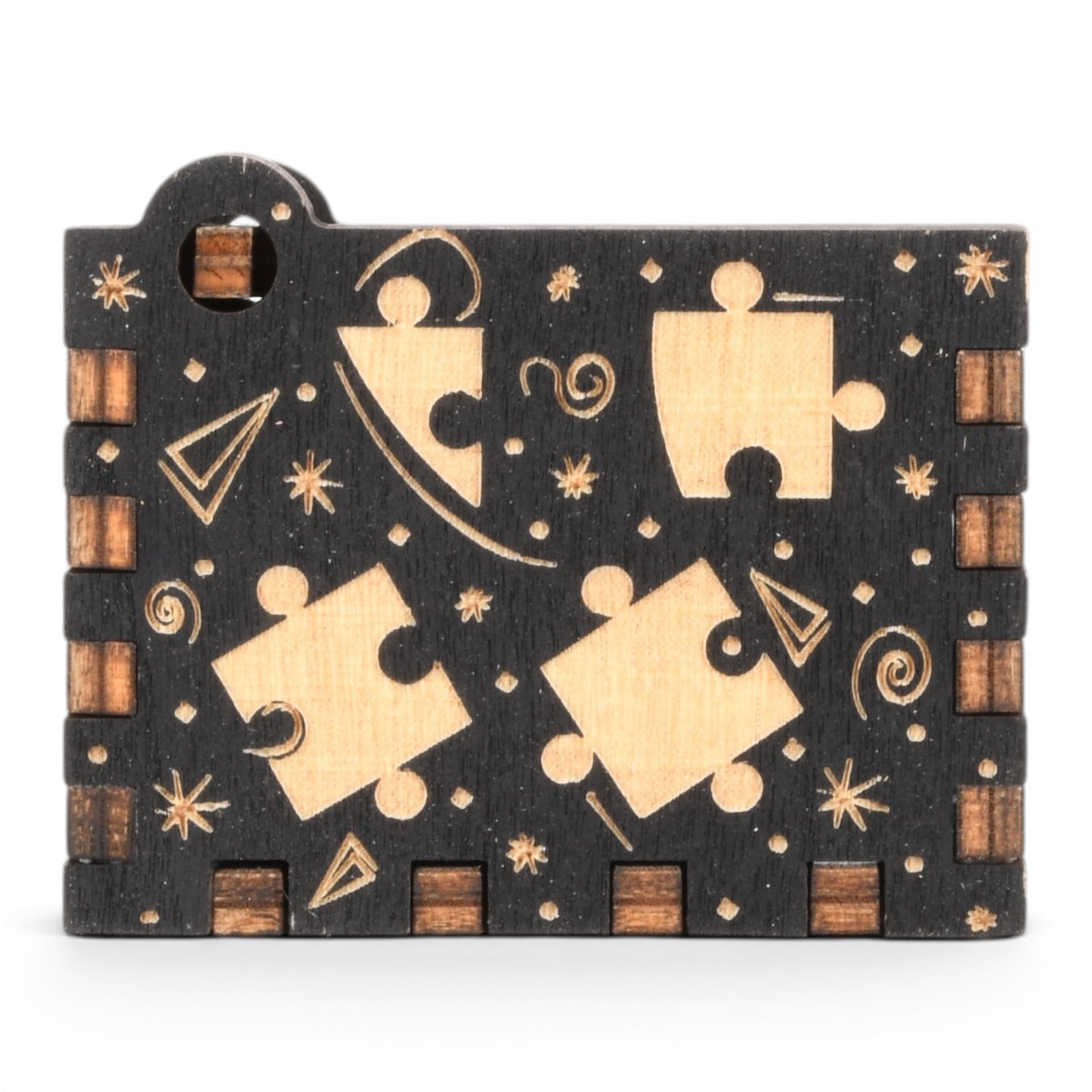 Enchanted Music Boxes puzzle piece design hand-crank music box in black and natural plywood with engraved details.