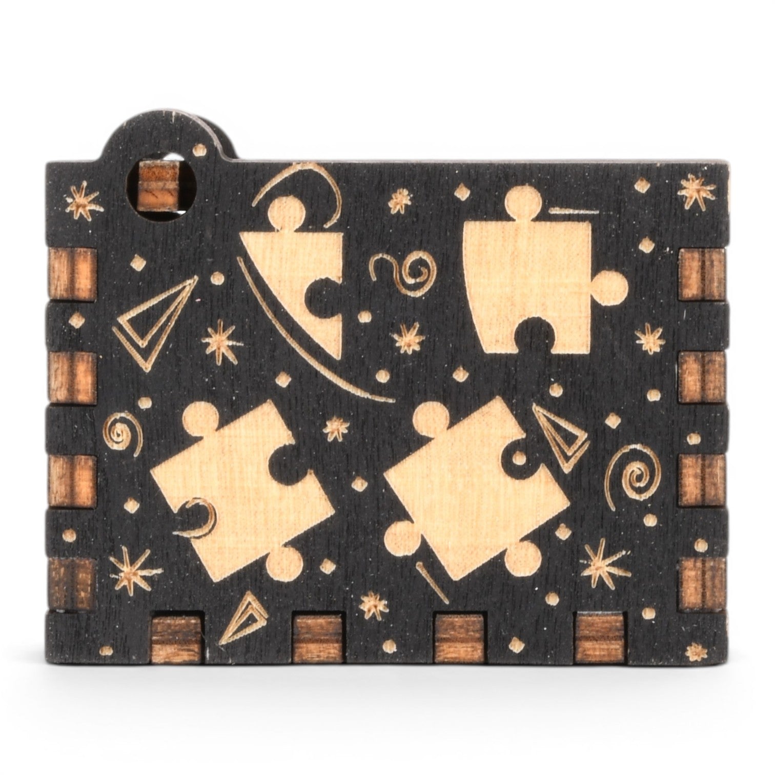 Enchanted Music Boxes puzzle piece design hand-crank music box in black and natural plywood with engraved details.