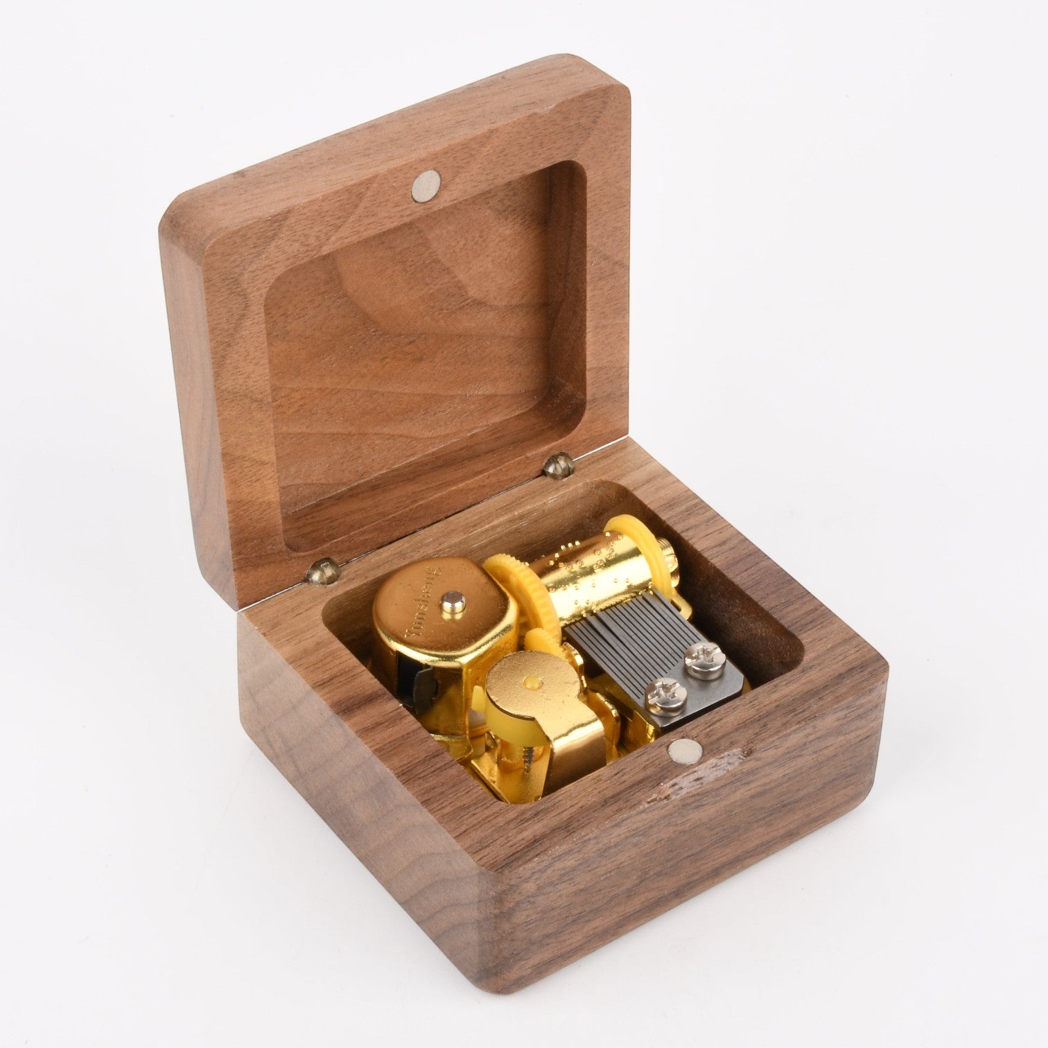 Enchanted Music Boxes square wooden wind-up music box with an exposed gold-tone metal mechanism inside.
