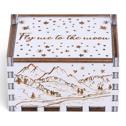 Enchanted Music Boxes plywood hand-crank music box with laser-engraved alpine mountain scene and starry night lid design.