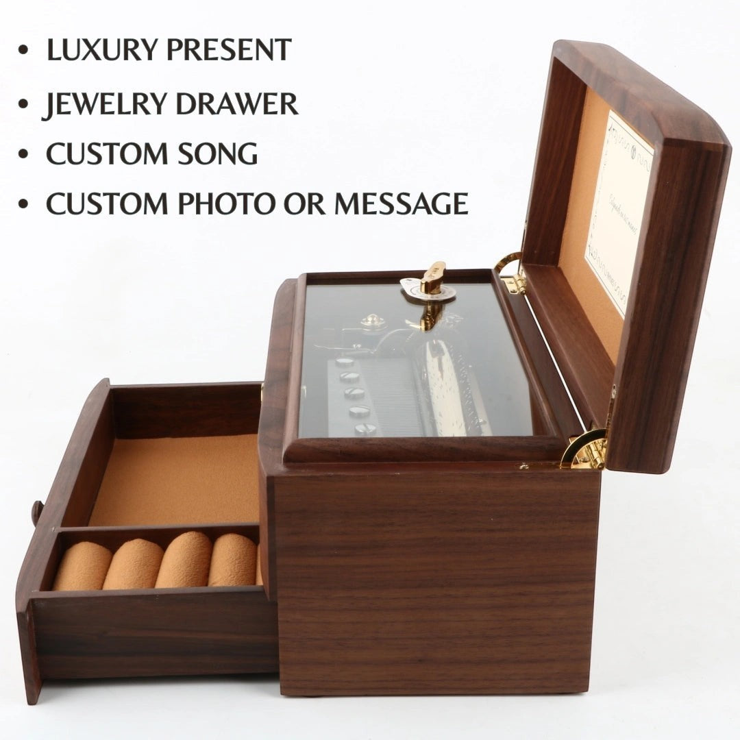 Enchanted Music Boxes 78-note walnut music box with open lid, visible mechanical movement, and pull-out jewelry drawer.