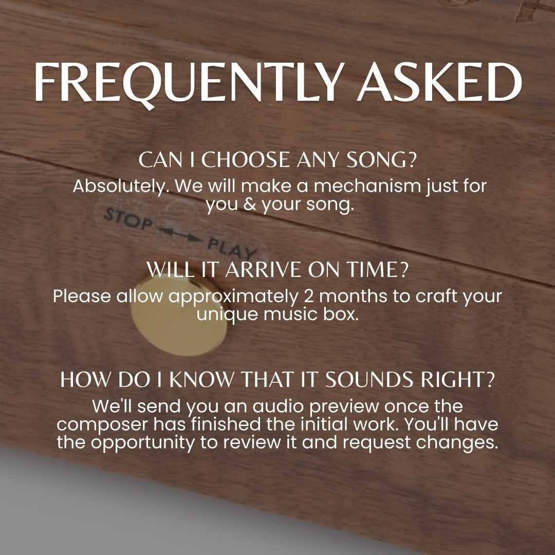 Enchanted Music Boxes walnut wood music box featuring a gold wind-up key and stop-play control on a glass panel.